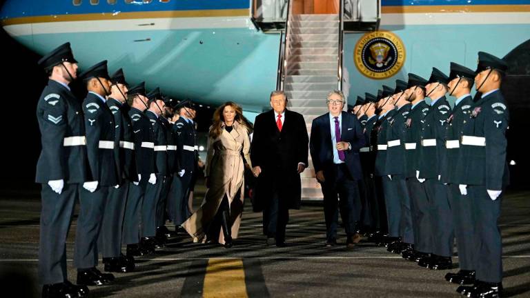 US President Donald Trump (C) and US First Lady Melania Trump disembark from Air Force One after landing at Stansted Airport, eastern England, on September 16, 2025, on the first day of a two-day visit to the UK. - ANDREW CABALLERO-REYNOLDS / AFP