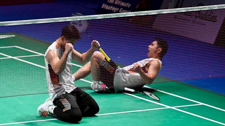 Nur Izzuddin (left) and Goh Sze Fei of Malaysia celebrate after winning against Kim Astrup and Anders Rasmussen of Denmark (not in pic) at the men’s doubles final match of the Clash Royale Arctic Open badminton event in Vantaa, Finland, on October 13, 2024. - Finland OUT