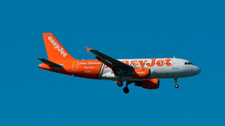 (FILES) This photo taken on August 27, 2018 shows an Airbus A319 of EasyJet as it flies above Toulouse, southern France. (Photo by PASCAL PAVANI / AFP)