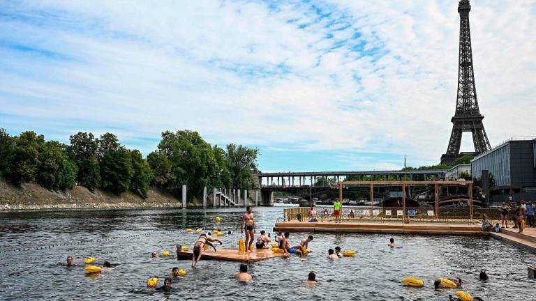 (FILES) People swim at the Grenelle safe bathing site on the Seine river on its opening day, in front of the Eiffel Tower in Paris on July 5, 2025. - JULIEN DE ROSA / AFP