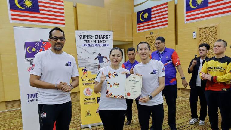 Timbalan Menteri Komunikasi Teo Nie Ching menyampaikan sijil penghargaan kepada jaguh larian menara negara, Soh Wai Ching selepas memanjat tingkat 37 Menara Komunikasi pada program Klinik Memanjat Tangga hari ini - BERNAMA