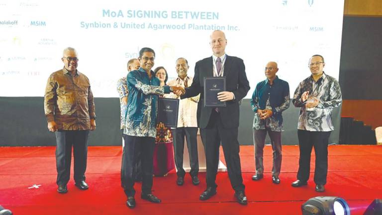 Zambry (far left) looks on as Umpsa Holdings CEO Syed Alwi Mohamed Sultan (left) and Iba Botanicals CEO Benjamin Mead, exchange documents.