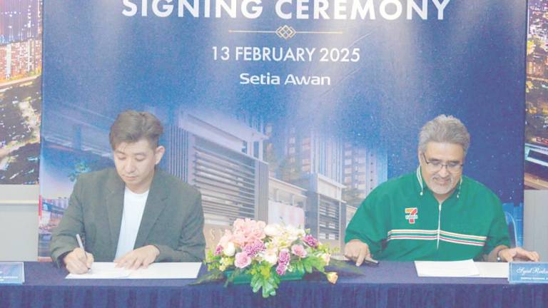 Tan (left) and 7-Eleven Malaysia general manager of store development Syed Redza Al-Gadrie Syed Hassan signing the MoU.