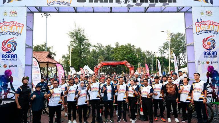 Timbalan Menteri Belia dan Sukan Adam Adli Abdul Halim (tengah) bergambar bersama peserta-peserta pada Majlis Pelepasan Cycling Tour ASEAN Solidarity di Dataran Pantai Batu Buruk hari ini. FotoBernama
