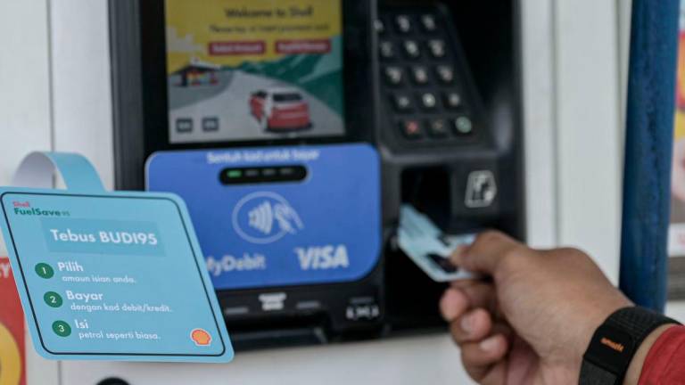 Pelanggan menggunakan kad pengenalan diri bagi mengesahkan kelayakan mendapatkan BUDI95 di stesen minyak Shell Jalan Tun Razak, semalam- BERNAMA