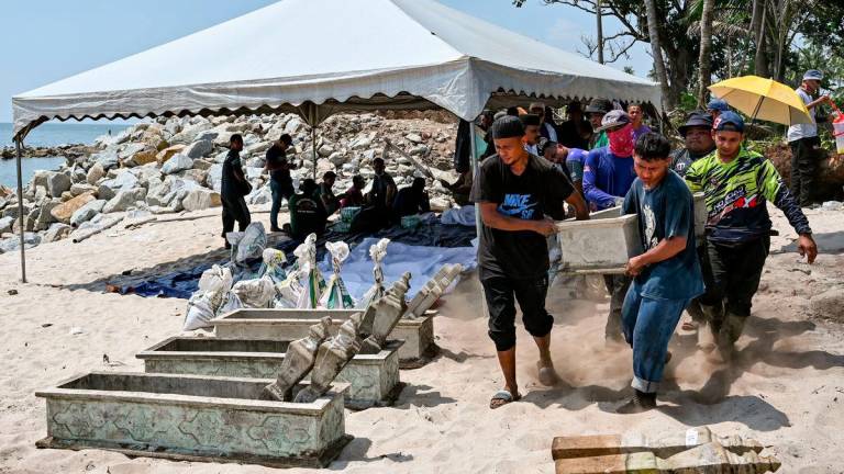 Waris dan ahli keluarga yang dipantau oleh pegawai Pejabat Agama Daerah Kuala Nerus mengangkat kepok kubur bagi proses dokumentasi jenazah selepas kubur digali semula untuk dipindahkan ke kawasan perkuburan lain semasa tinjauan di Tanah Perkuburan Islam Kampung Pengkalan Maras, hari ini. - fotoBERNAMA