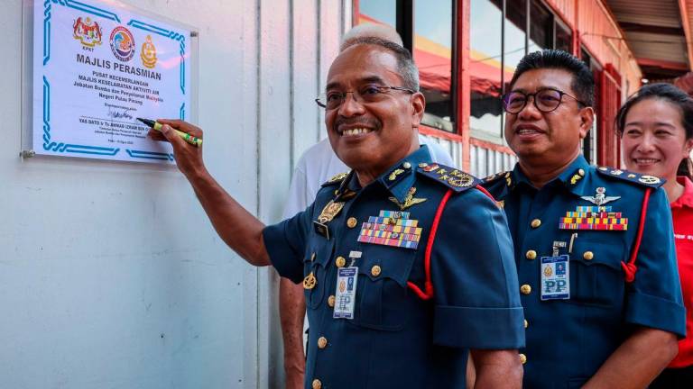 Timbalan Ketua Pengarah (Operasi) Jabatan Bomba dan Penyelamat Malaysia (JBPM), Datuk Ahmad Izram Osman (kiri) menandatangani plak perasmian Pusat Kecemerlangan Majlis Keselamatan Aktiviti Air JBPM di Pangkalan Unit Marin Bomba, Mak Mandin, hari ini - fotoBERNAMA