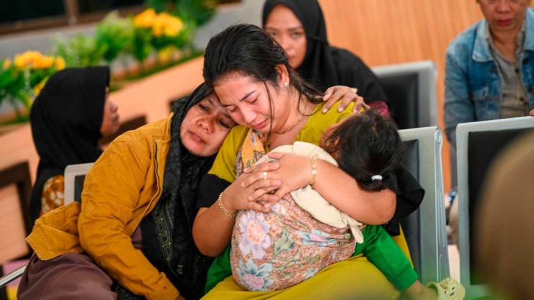 Keluarga menunggu berita mengenai sebuah feri yang karam - AFP