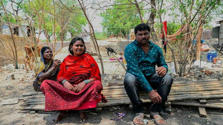 In this photograph taken on May 4, 2025, Manisha Barde (C), a sugarcane worker who was married as a child bride, is pictured along with her husband, Balu Somnath Barde (R), near their home at Umrad Khalsa village in Beed district of India’s state of Maharashtra. When wedding season comes in India, the phone of child rights activist Tatwashil Kamble never stops ringing with appeals to stop girls from being married off due to poverty. India accounts for one in three of the world’s child brides, according to the UN children’s agency, with at least 1.5 million girls getting married each year. - Indranil MUKHERJEE / AFP