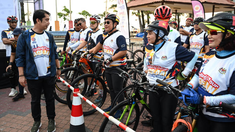 Deputy Minister of Youth and Sports, Adam Adli Abdul Halim (left), interacts warmly with participants at the Flag-Off Ceremony of the ASEAN Solidarity Cycling Tour at Dataran Pantai Batu Buruk today. – BERNAMA