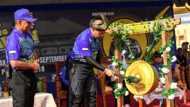 Ketua Polis Perak Datuk Noor Hisam Nordin (kanan) memukul gong tanda simbolik ketika hadir pada perasmian Program Ter...Paling Pahlawan Challenge 2025 di Padang Speedy hari ini. Turut bersama Ketua Polis Daerah Hilir Perak ACP Dr Bakri Zainal Abidin (kiri) - fotoBERNAMA