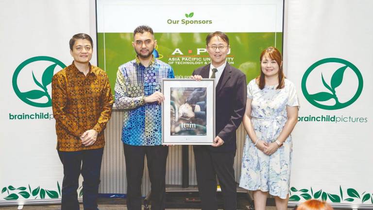 Deputy Minister Khairul, (second from left) hands over framed commemorative poster of Itam, to Dr Ho. Also present, filmmaker and director Tan, (first left) and Head of SoMAD, Debbie Liew.