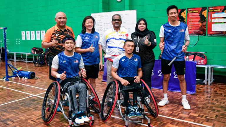 Head of the Malaysian Contingent (CDM) to the Paris Paralympics, Datuk Subramaniam Raman Nair (centre, back) poses with Para Badminton athletes, Muhammad Ikhwan Ramli (right, front) and Noor Azwan Noorlan (left, front) - BERNAMApix