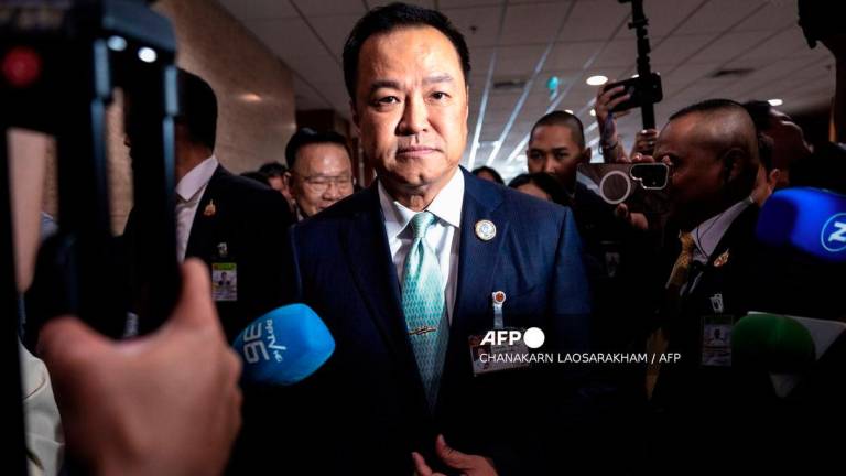 Bhumjaithai Party leader Anutin Charnvirakul (C) is surrounded by media members as he leaves a press conference after securing the backing of opposition People's Party to serve as Thailand's next prime minister at the parliament in Bangkok on September 3, 2025. - AFP