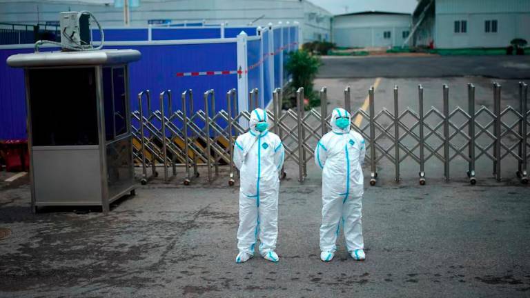 Workers in protective suits are seen at the Leishenshan Hospital, a makeshift hospital for treating patients with the coronavirus disease (COVID-19), in Wuhan, Hubei province, China April 11, 2020. - REUTERS