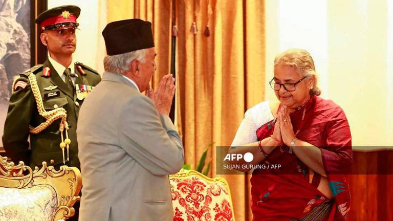 Nepal’s President Ram Chandra Paudel (L) gestures after administering the oath to the country’s newly appointed Prime Minister Sushila Karki during her swearing-in-ceremony at the President House in Kathmandu on September 12, 2025. Nepal’s former chief justice Sushila Karki was sworn on September 12 to lead the transition as the country’s next prime minister after deadly anti-corruption protests ousted the government. (Photo by Sujan GURUNG / AFP)