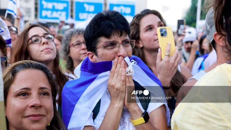 A woman reacts as people celebrate at Hostage Square in Tel Aviv as news came out that Hamas has already handed over seven surviving hostages to the Red Cross on October 13, 2025. - AFP