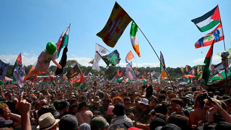 Revellers gather as Kneecap performs at Glastonbury Festival at Worthy Farm in Pilton, Somerset, Britain, June 28, 2025. REUTERS/Jaimi Joy/File Photo