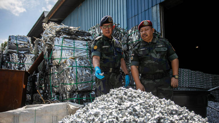 Deputy Commander of the Northern Brigade, ACP Shamsul Baharin Aman (left), displays processed aluminium during a press conference regarding the success of the Intelligence Unit of the Northern Brigade Headquarters and Battalion 3 of the General Operations Force (PGA) at the Pengkalan 4 Industrial Area here today. – BERNAMA