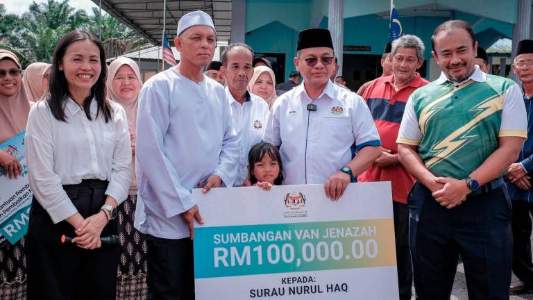 Menteri di Jabatan Perdana Menteri (Hal Ehwal Agama) Datuk Dr Mohd Na'im Mokhtar (tiga, kanan) diiringi Timbalan Menteri Komunikasi yang juga Ahli Parlimen Kulai Teo Nie Ching (dua, kiri) menyerahkan replika cek sebanyak RM100,000 kepada Pengerusi Surau Nurul Haq Kampung Sungai Sayong 1 Mohd Anuar Repan (tiga, kiri) bagi tujuan pembelian semula van jenazah yang dicuri baru-baru ini di Kampung Sungai Sayong hari ini. - BERNAMA