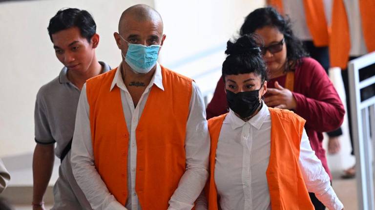 British national Elliot James Shaw (L) and Argentinian national Eleonora Gracia (R) walk to a court room in Denpasar on Indonesia’s resort island of Bali on July 24, 2025. (Photo by SONNY TUMBELAKA / AFP)