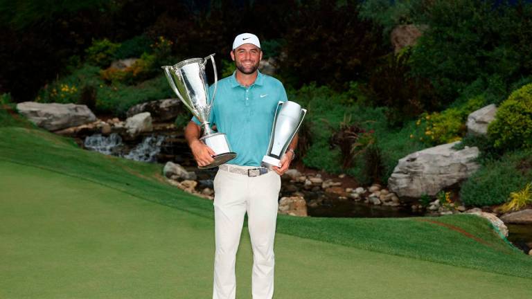 Scottie Scheffler of the United States poses with the Western Golf Association (WGA) Open J.K. Wadley Championship Cup trophy and the tournament trophy after the final round of the BMW Championship 2025. -Kevin C. Cox/Getty Images/AFP