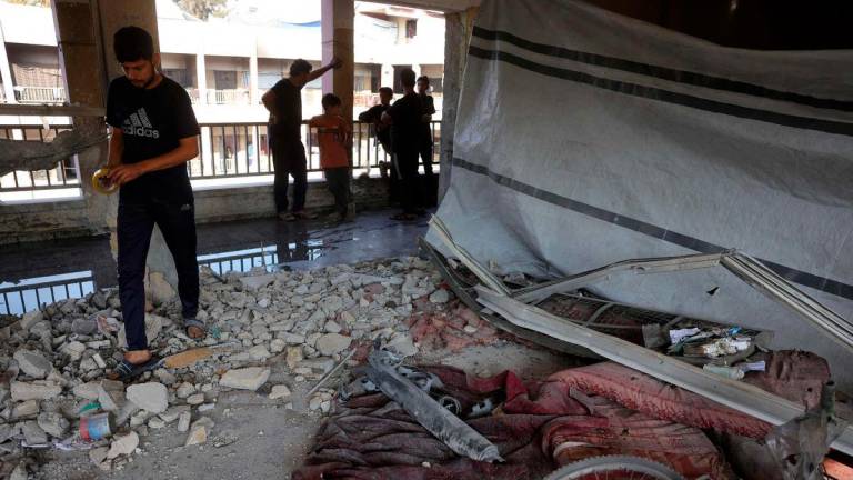 Displaced Palestinians check the destruction in a classroom used as a temporary shelter, inside a school hit by an Israeli strike in the Al-Iskandar neighbourhood, north of Gaza City on June 26, 2025. (Photo by BASHAR TALEB / AFP)
