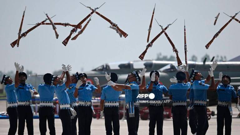 Indian Air force cadets toss their rifles during a full dress rehearsal ahead of MIG-21 Bison fighter jet farewell at Chandigarh Airforce Station on September 24, 2025. - AFP