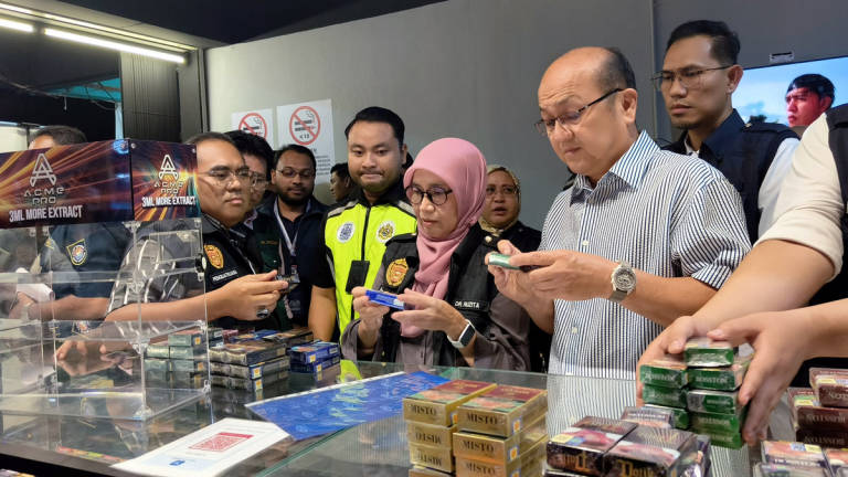 Melaka State Executive Councillor for Health, Human Resources, and Unity, Datuk Ngwe Hee Sem (right), and State Director of Health, Dr Ruzita Mustaffa (second from right), inspect cigarettes believed to be counterfeit or smuggled, sold at prices below RM12, during the “Operasi Selamat Paru-Paru” late last night. – BERNAMA