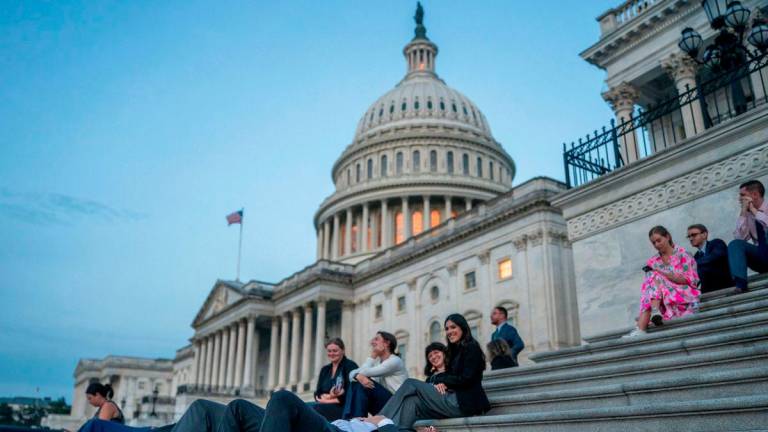 Senate staffers rest on the U.S. Capitol steps at sunrise as Republican lawmakers struggle to pass U.S. President Donald Trump's sweeping spending and tax bill, on Capitol Hill in Washington, D.C., U.S., July 1, 2025. - REUTERSPIX