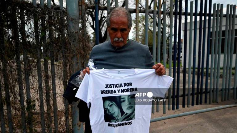 Antonio Del Castillo, grandfather of Brenda del Castillo and Morena Verdi, holds a shirt with their image demanding justice for their murder in La Tablada, on the outskirts of Buenos Aires, on September 26, 2025. (Photo by Luis ROBAYO / AFP)