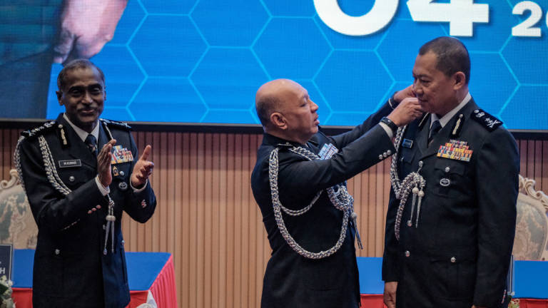 Bukit Aman Director of Management, Datuk Abdul Aziz Abdul Majid (centre), affixes the rank insignia on the new Johor Police Chief, Commissioner of Police Ab Rahaman Arsad (right), witnessed by former Johor Police Chief, Datuk M. Kumar, at the Johor Police Chief Handover Ceremony held at the Johor Contingent Police Headquarters today. – BERNAMA
