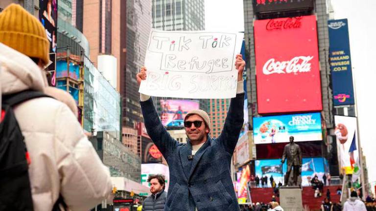 A social media influencer films a video for his new Xiaohongshu, also known as RedNote, after leaving TikTok, in Times Square in New York City - REUTERSpix