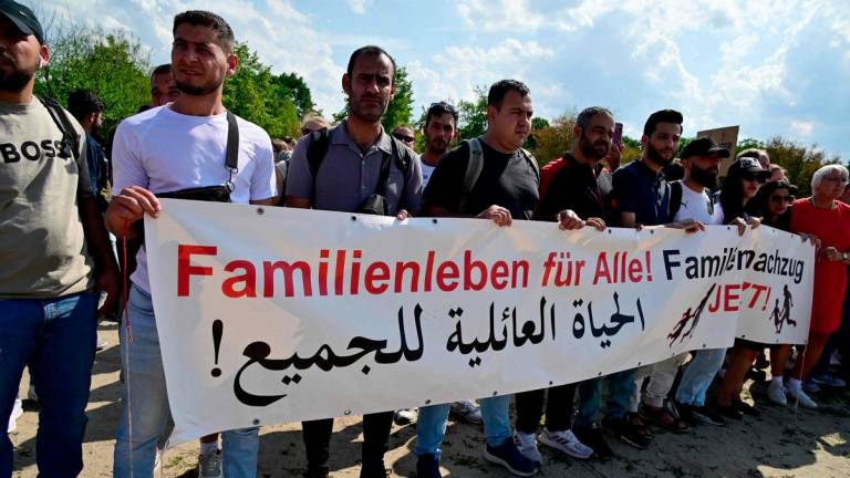 Demonstrators hold a banner reading in German and in Arabic Familz life for all! Family reunification now! as they protest in front of the Reichstag building that houses the Bundestag (lower house of parliament) against the German government's migration policy, on June 26, 2025 in Berlin. - AFPPIX