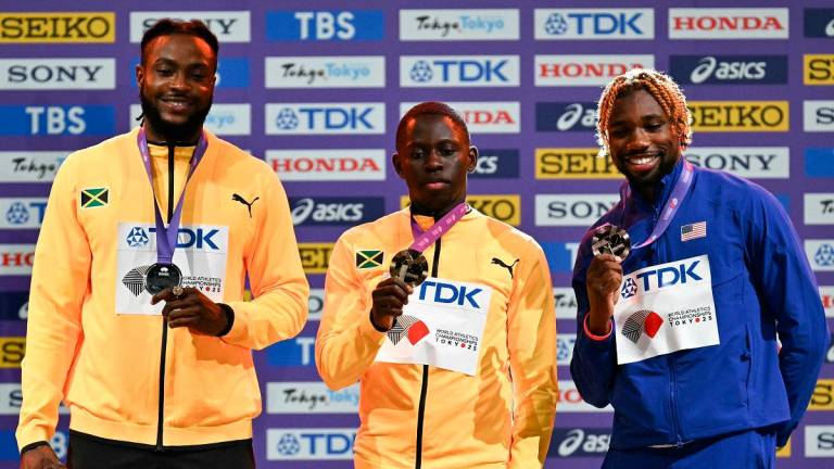 (L-R) Silver medallist Jamaica’s athlete Kishane Thompson, gold medallist Jamaica’s athlete Oblique Seville and bronze medallist US’ athlete Noah Lyles pose with their medals on the podium for the men’s 100m final during the World Athletics Championships in Tokyo on September 15, 2025. - Philip FONG / AFP