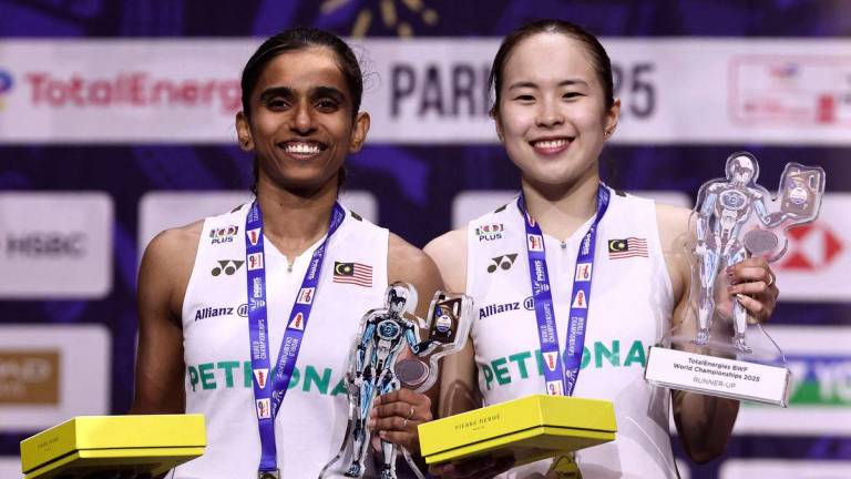 Pemenang pingat perak dari Malaysia, Thinaah Muralitharan dan Pearly Tan, meraikan kejayaan di atas podium bersama pingat dan trofi mereka selepas perlawanan akhir beregu wanita di Kejohanan Badminton Dunia BWF yang berlangsung di Arena Adidas, Paris, pada 31 Ogos 2025. (Foto oleh Thibaud MORITZ / AFP)