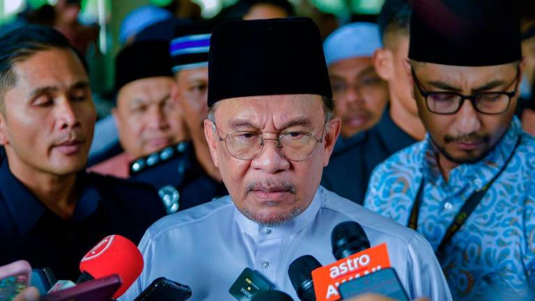 Prime Minister Datuk Seri Anwar Ibrahim speaking to reporters after performing Friday prayers at Al Khadijah Mosque, Jalan Pantai Sentral 2, yesterday. – BERNAMA