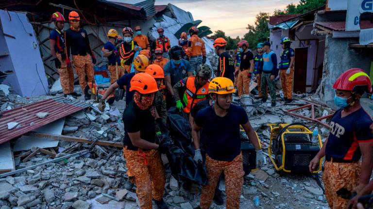 Rescuers carry a victim’s body recovered from a damaged pension house in the aftermath of a magnitude 6.9 quake in Bogo, Cebu, Philippines, October 1, 2025. REUTERS/Eloisa Lopez