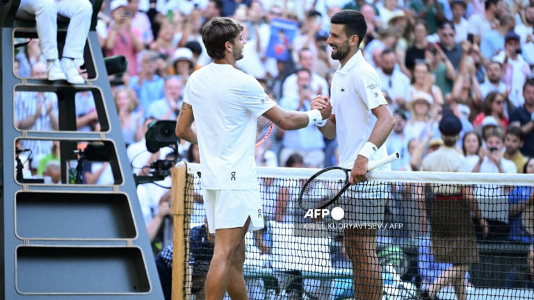 Serbia’s Novak Djokovic shakes hands with Italy’s Flavio Cobolli after winning during their men’s singles quarter-final tennis match on the tenth day of the 2025 Wimbledon Championships at The All England Lawn Tennis and Croquet Club in Wimbledon, southwest London, on July 9, 2025. - AFP