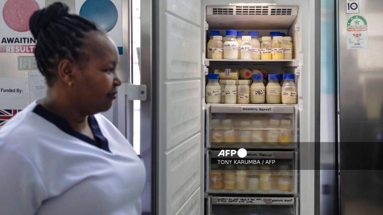 Hannah Wangeci Maina, a senior nurse stands near reserves of donated breastmilk preserved in a freezer to await screening at a human milk bank in the Pumwani Maternity Hospital, Nairobi on September 4, 2025. (Photo by Tony KARUMBA / AFP)
