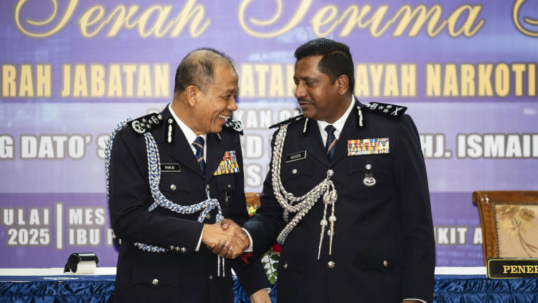 Inspector-General of Police Datuk Seri Mohd Khalid Ismail (left) shakes hands with the new Director of the Narcotics Crime Investigation Department (NCID), Datuk Hussein Omar Khan (right), during the NCID Director Handover Ceremony at the Senior Police Officers’ Mess in Bukit Aman today. – BERNAMA