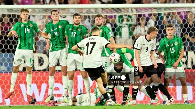 Germany's midfielder #17 Florian Wirtz (C) kicks to score the 3-1 goal during the 2026 World Cup qualifiers Europe zone group A football match between Germany and Northern Ireland on September 7, 2025 in Cologne, western Germany. - AFP