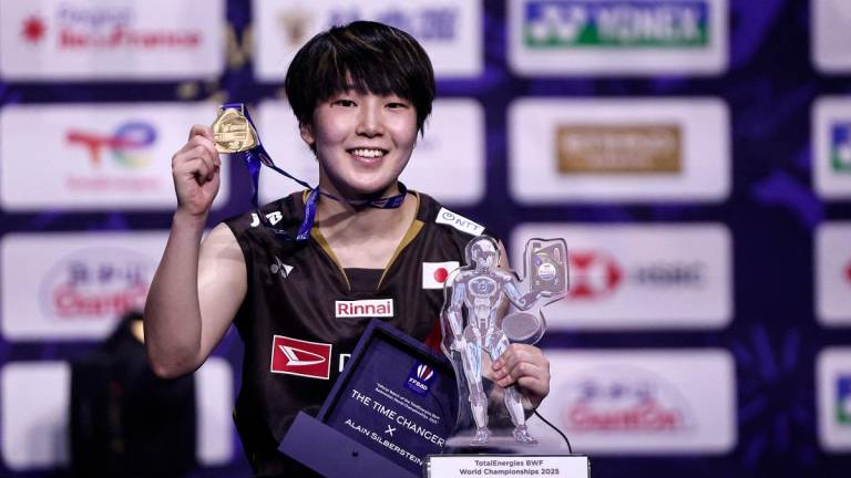 Japan’s Akane Yamaguchi holds her trophies as she celebrates on the podium after beating China’s Chen Yu Fei during the women’s singles final match at the Badminton BWF World Championships at the Adidas Arena in Paris, on August 31, 2025. - Thibaud MORITZ / AFP