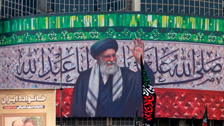 A billboard depicting Iran’s Supreme Leader Ayatollah Ali Khamenei is displayed in the centre of Tehran’s Valiasr Square on July 13, 2025. (Photo by ATTA KENARE / AFP)