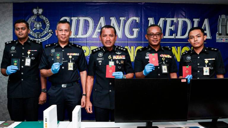 Ketua Polis Daerah Dang Wangi, ACP Sulizmie Affendy Sulaiman menunjukkan pasport yang dirampas pada sidang media di Ibu Pejabat Polis Daerah Dang Wangi, hari ini- BERNAMA