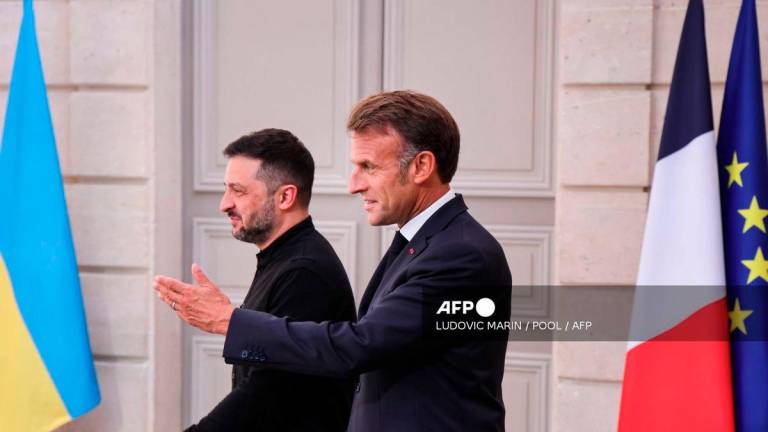 Ukraine's President Volodymyr Zelensky (L) and France's President Emmanuel Macron arrive to give a press conference following the Coalition of the Willing Summit, at the Elysee presidential Palace, in Paris, on September 4, 2025. - POOL via AFP