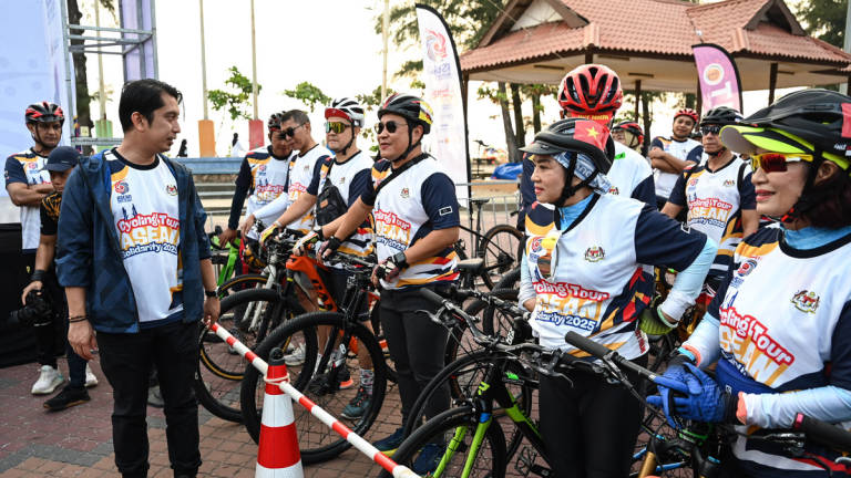 Deputy Minister of Youth and Sports, Adam Adli Abdul Halim (left), mingles with participants at the Flag-Off Ceremony of the ASEAN Solidarity Cycling Tour at Dataran Pantai Batu Buruk today. – BERNAMA