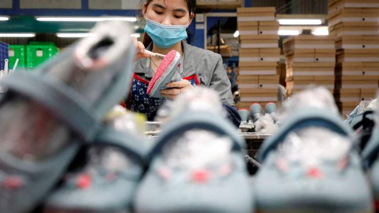 An employee works at a shoe factory for export in Hanoi, Vietnam December 29, 2020. - REUTERSPIX