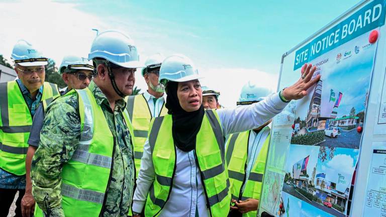 Works Minister Datuk Seri Alexander Nanta Linggi (left) listens to an explanation on the design of the Integrated EV Charging Hub by PLUS Malaysia Managing Director, Datuk Airina Nik Jaafar (centre), during the Groundbreaking Ceremony for Malaysia’s First Integrated EV Charging Hub at the Seremban R&amp;R (Southbound), today. – BERNAMA