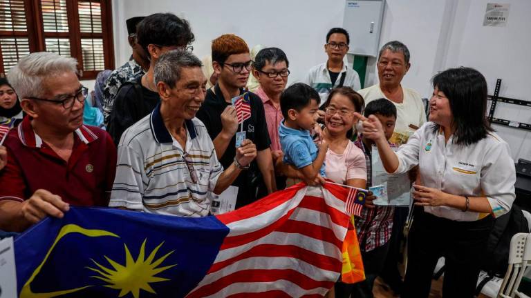 Pengerusi Jawatankuasa Pembangunan Sosial, Kebajikan dan Hal Ehwal Bukan Islam Pulau Pinang Lim Siew Khim (kanan) beramah mesra dengan penerima kad pengenalan Kewarganegaraan Malaysia pada Program Kewarganegaraan Pulau Pinang hari ini- fotoBERNAMA